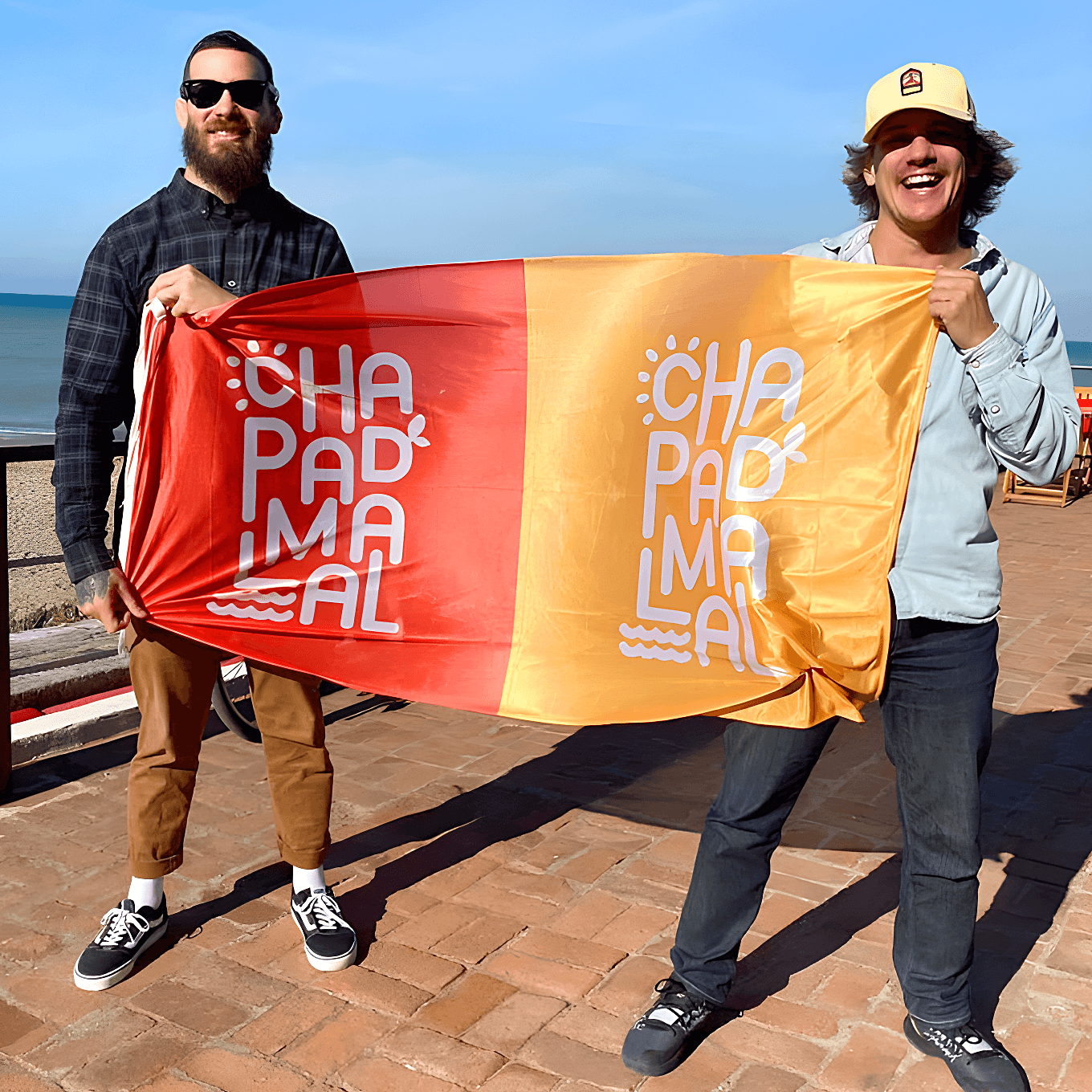 Aplicación de marca en banderas dos personas sosteniendo una bandera con la aplicación de marca de Chapa